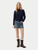 Model trägt navyfarbenes Kaschmiroberteil mit Stehkragen zu Jeansrock, Ganzkörperansicht von vorne