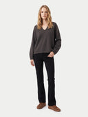 Modell trägt braunen Damen Kaschmir Pullover mit V-Ausschnitt und schwarzer Hose, Vorderansicht