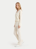 Seitenansicht des weißen Pullovers mit leichter Silhouette und Strickhose